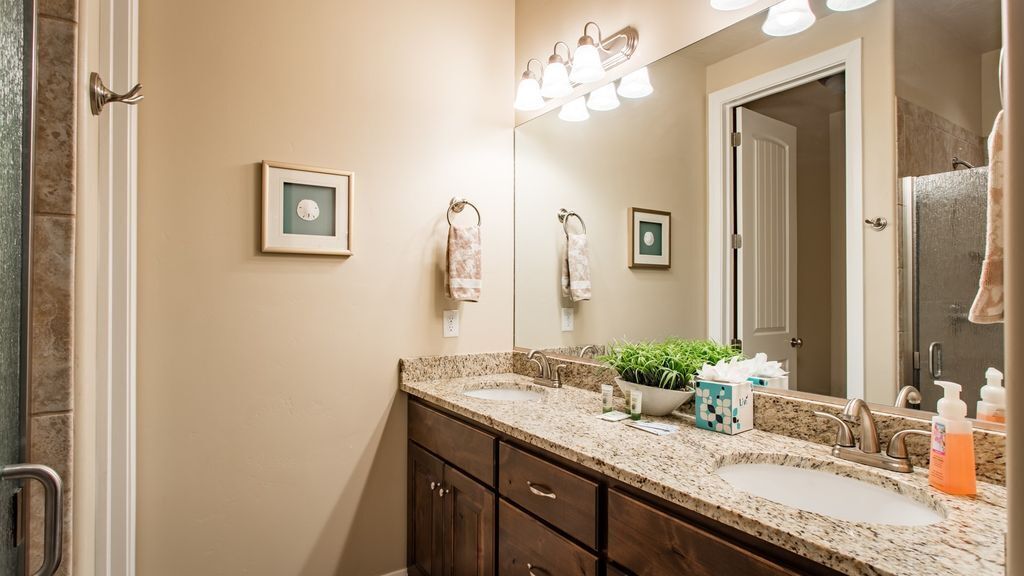 A bathroom with two sinks, a mirror, and a towel rack.