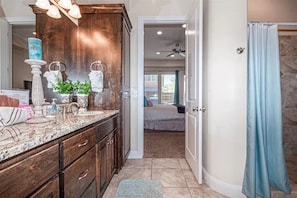 A bathroom with a large vanity, a mirror, and a shower area. - Pebble Beach (Washington)
