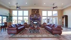 A spacious lobby with a stone fireplace, leather sofas, and a large window offering a view of the outside. - Pebble Beach (Washington)