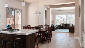 A spacious kitchen with a central island, dark cabinetry, and a dining area with wooden chairs. - Red Cliffs (Washington)