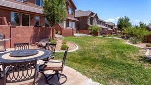 A residential area with houses, a patio with a table and chairs, and a well-maintained lawn. - Red Cliffs (Washington)
