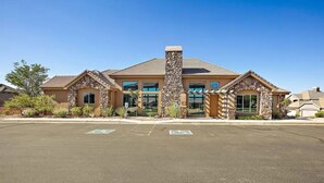 A two-story building with a stone facade, large windows, and a parking lot in front. - Red Cliffs (Washington)