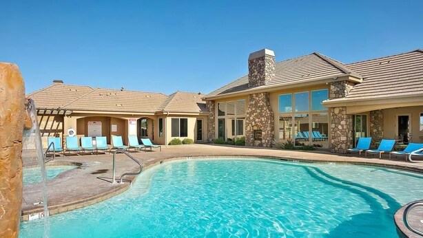 A swimming pool with lounge chairs and a stone building with large windows. - Road Runner Retreat (Washington)