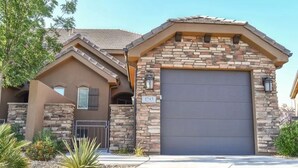 A two-story house with a stone facade, a garage, and a clear driveway. - Solana Linda (Washington)