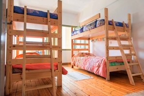A bunk bed room with wooden frames, a ladder, and a window with daylight. - Lima Sol House - Hostel (Limassol)