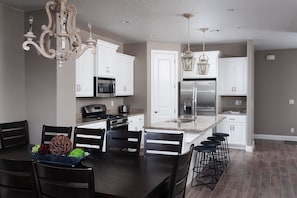Enjoy casual dining at the central island with bar stools, featuring a microwave, oven, and refrigerator.