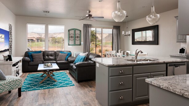 A modern kitchen with a central island, a dining area with a view, and a living room with a sofa and coffee table. - Your Escape at the Ledges (St. George)