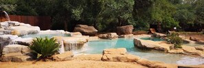 A natural pool surrounded by rocks and trees.