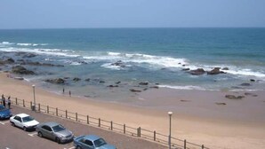 Una playa con zona de estacionamiento y vista al océano.