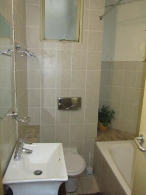 Un baño con lavamanos, inodoro y bañera.