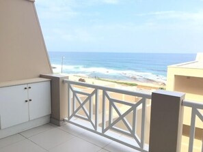 Un balcón con vista al océano y a la playa.