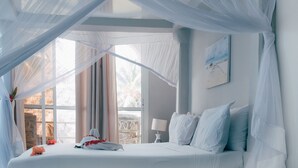 A bedroom with a bed, a window, and a painting on the wall. - Paje Beach Apartments & Hotel (Paje)