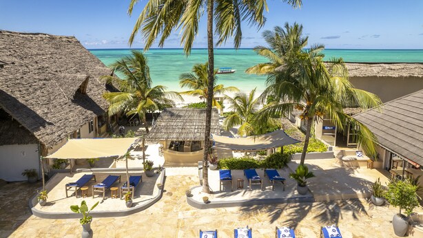 A resort with a pool, lounge chairs, and a view of the ocean. - Paje Beach Apartments & Hotel (Paje)