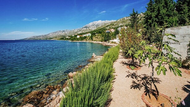 A coastal landscape with clear blue sea, rocky shoreline, and greenery. - Apartment in Starigrad near the Sea (Starigrad Paklenica)