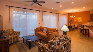 A living room with a sofa, armchairs, a coffee table, and a dining area with chairs and a table. - Paraiso Del Mar Resort PDM V261 3 Bedroom Villa by Seaside La Paz (La Paz)
