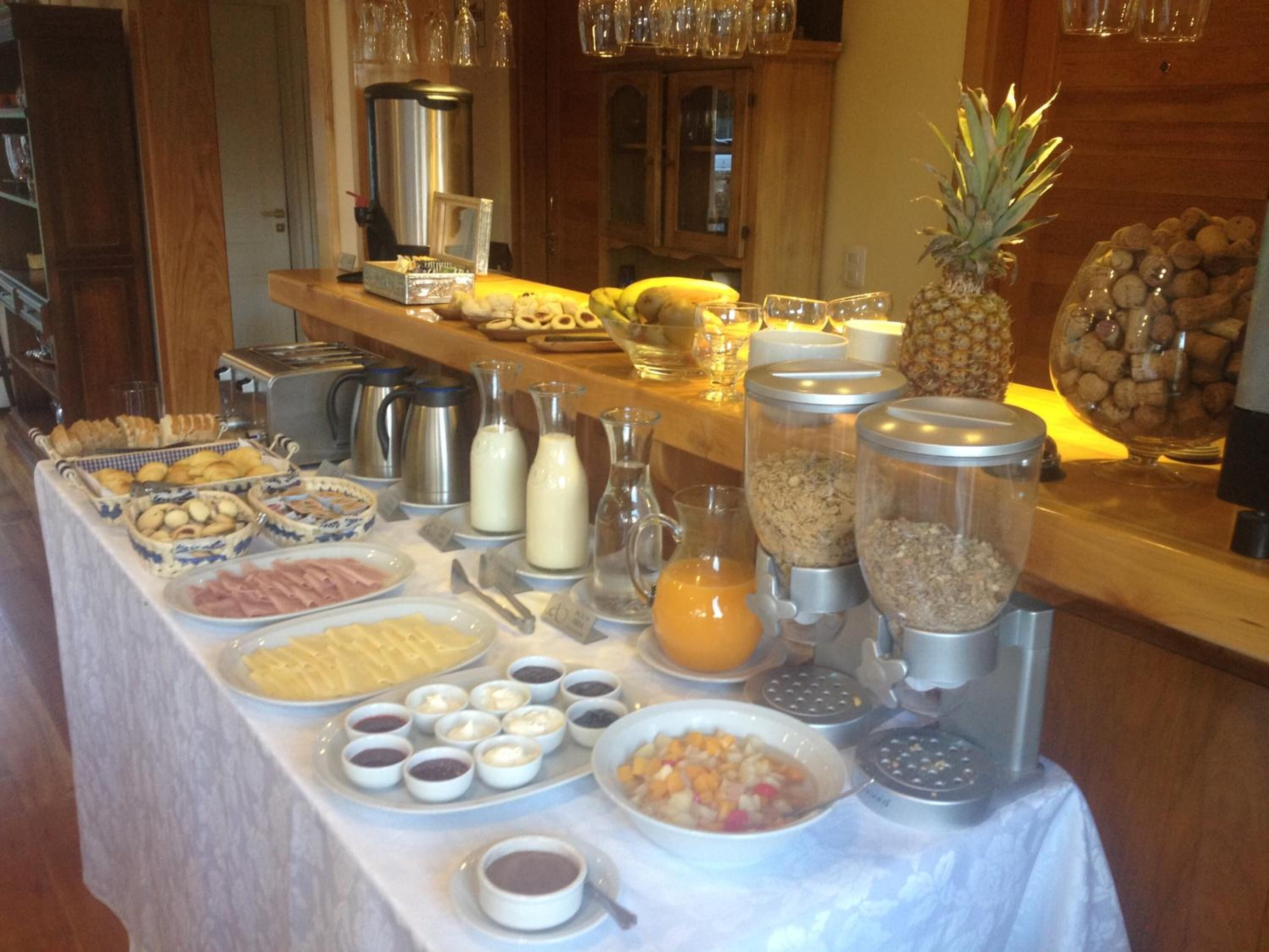 Disposição de buffet com diversos alimentos, bebidas e acompanhamentos.