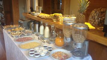 Disposição de buffet com diversos alimentos, bebidas e acompanhamentos.