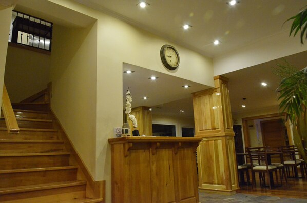 Una escalera de madera que conduce a un rellano con un reloj en la pared.
