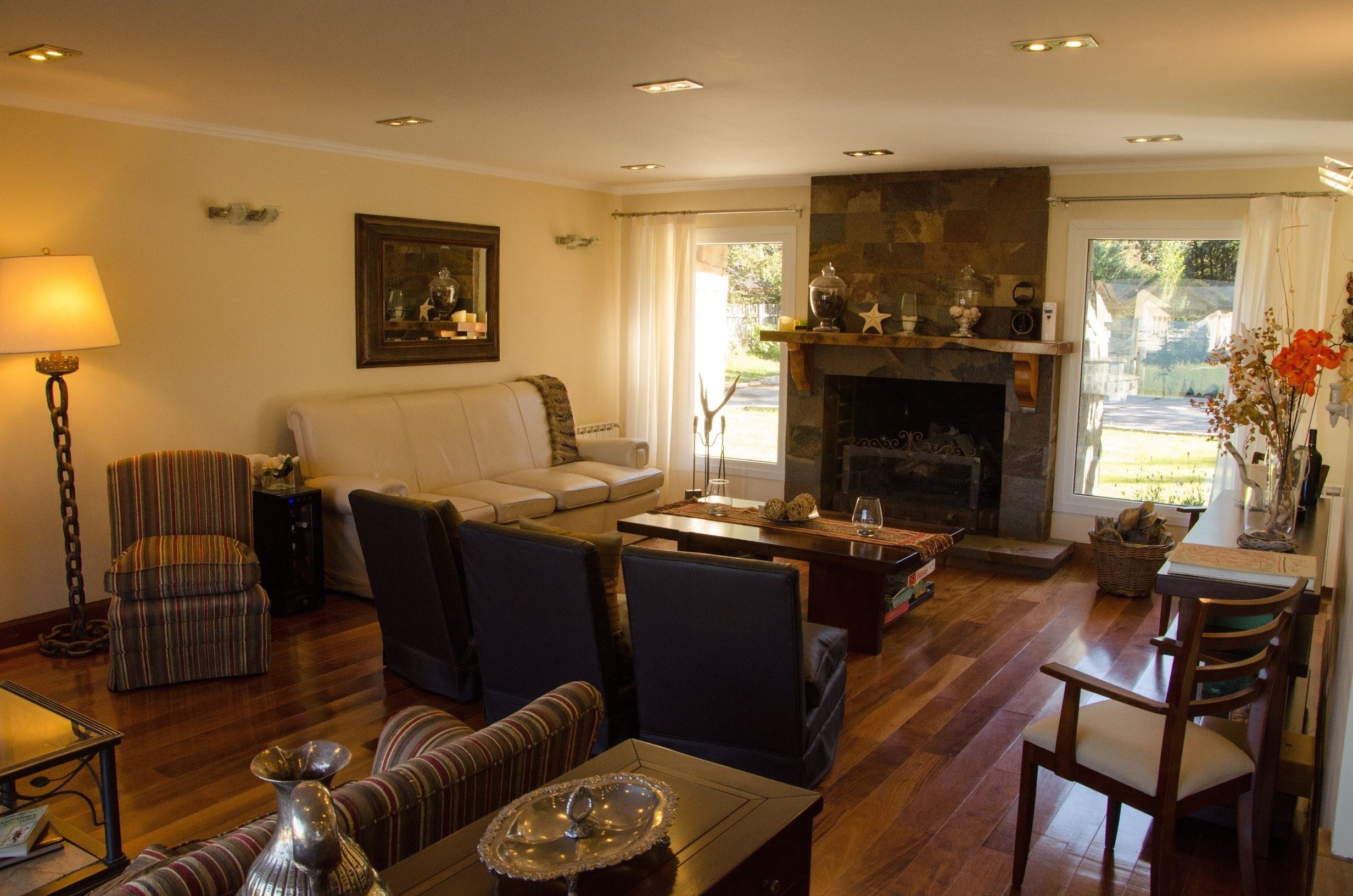 A cozy living room with a fireplace, a sofa, a dining table, and a lamp.