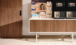 Una cocina moderna con armarios de madera, encimera blanca y una cafetera.