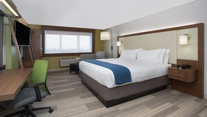 Habitación de hotel con cama, escritorio, silla y ventana.