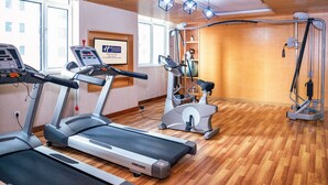 Academia com esteiras, elípticos e barra para puxar.