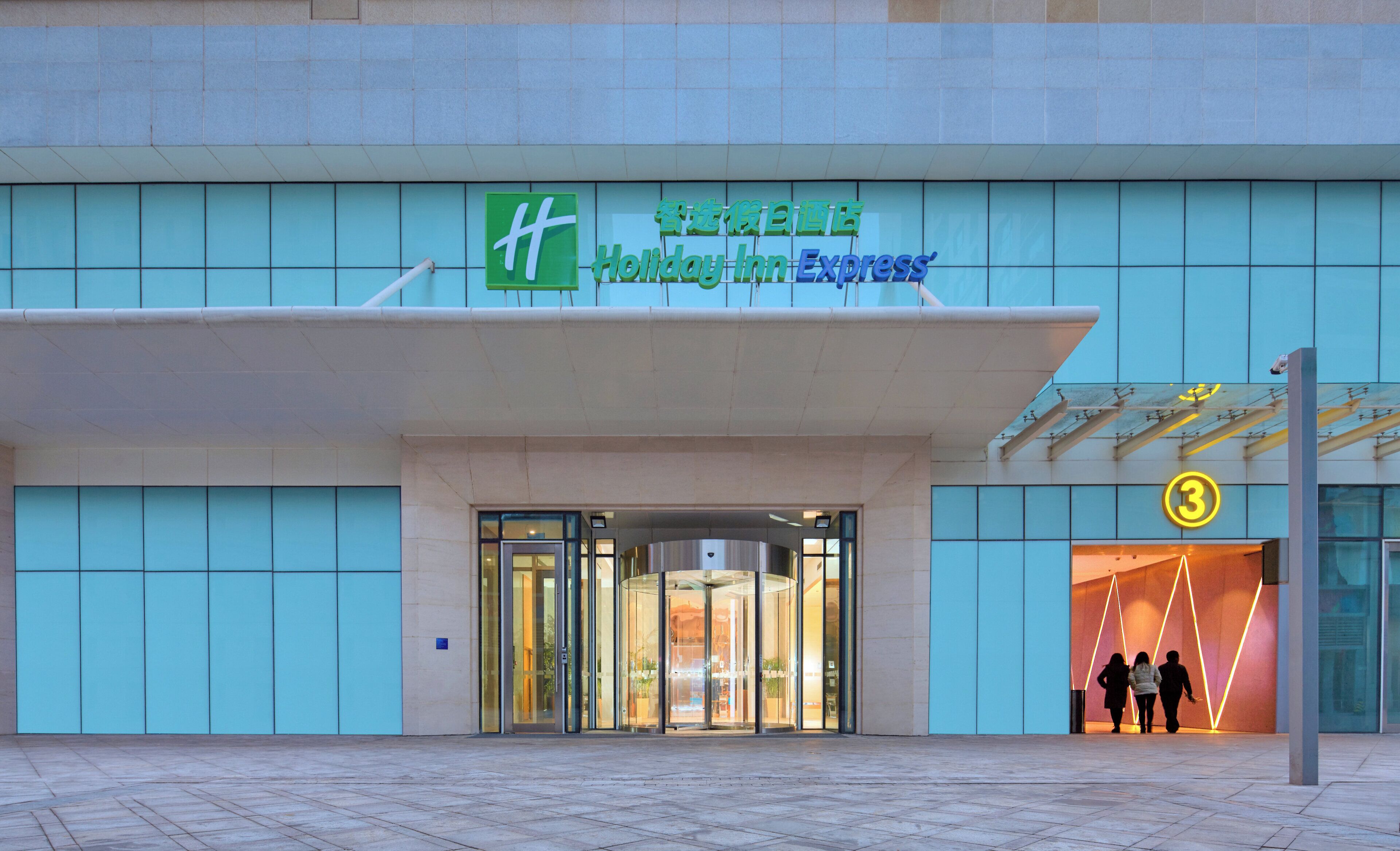 A Holiday Inn Express building with a glass entrance and a sign above it.