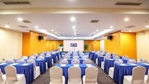 A conference room with rows of tables and chairs, equipped with water bottles and name cards. - Holiday Inn Express Tangshan Downtown by IHG (Tangshan)