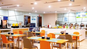 A modern restaurant with multiple tables and chairs, a noodle bar, and a variety of food items displayed. - Holiday Inn Express Tangshan Downtown by IHG (Tangshan)