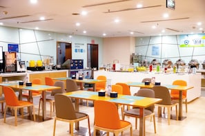 A modern restaurant with multiple tables and chairs, a noodle bar, and a variety of food items displayed. - Holiday Inn Express Tangshan Downtown by IHG (Tangshan)