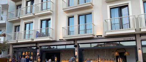 Un edificio de varios pisos con balcones y un restaurante en la planta baja llamado DALIDA.