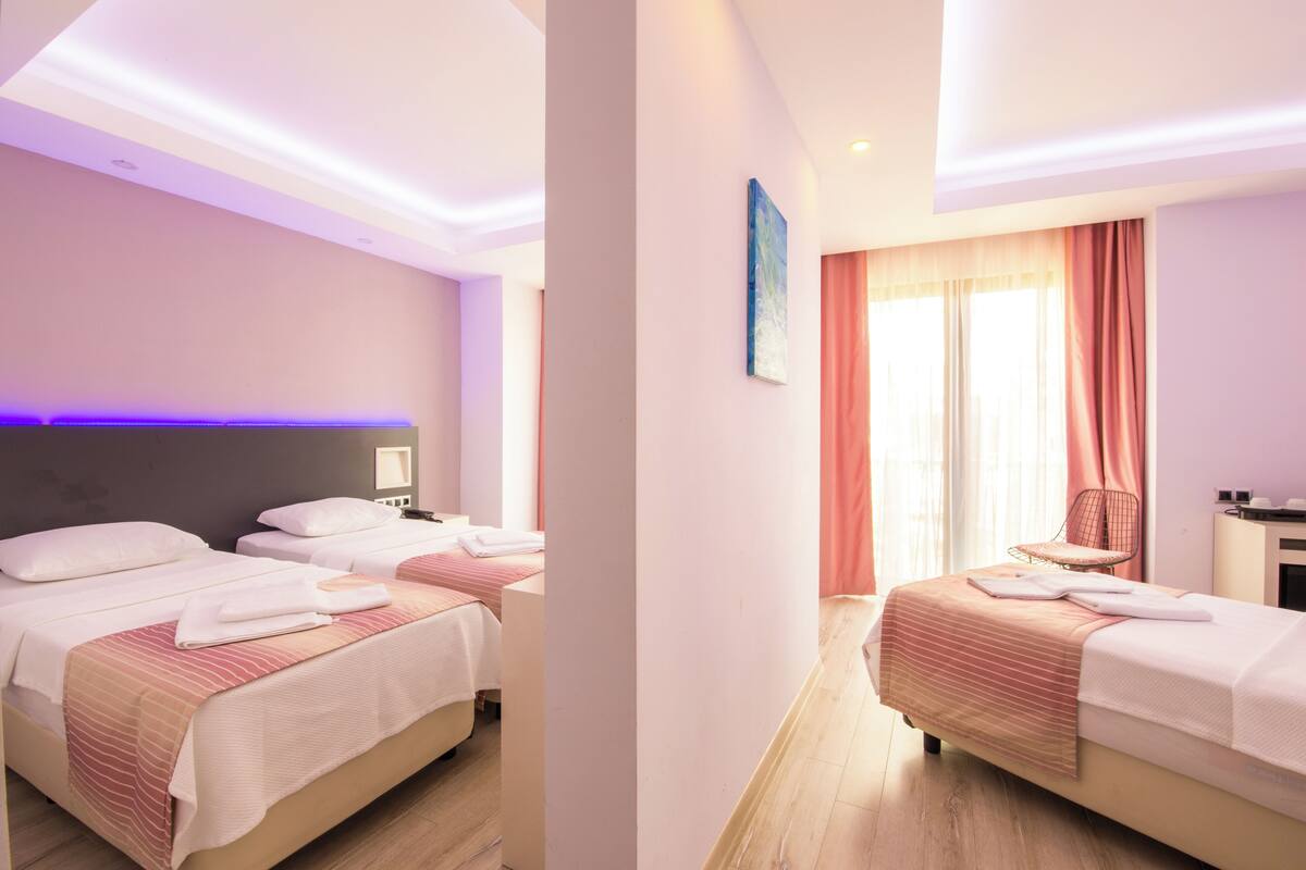 A hotel room with two beds, a desk, and a chair.