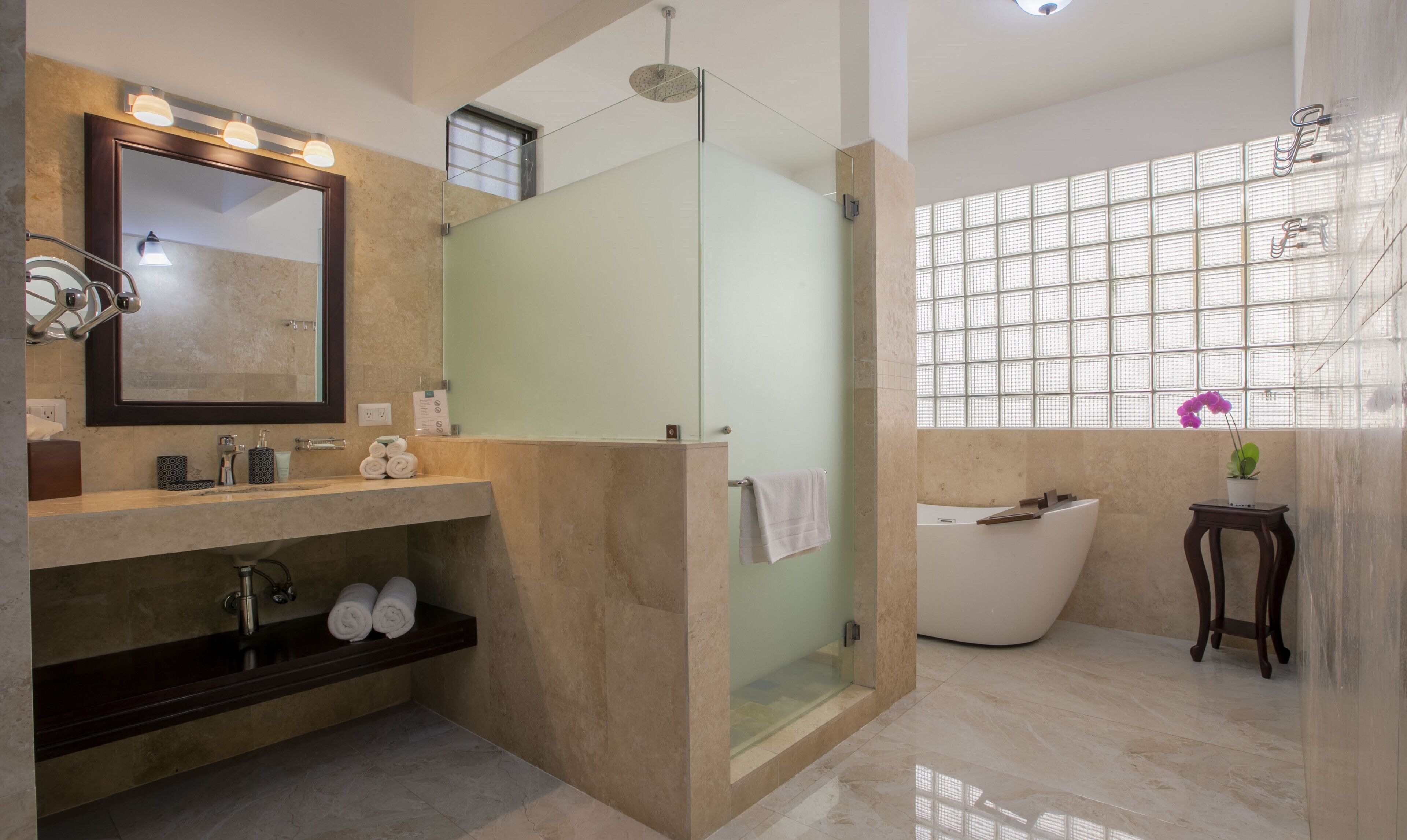 Une salle de bain moderne avec un grand miroir, une baignoire et un espace douche.