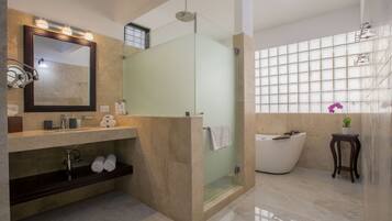 Une salle de bain moderne avec un grand miroir, une baignoire et un espace douche.