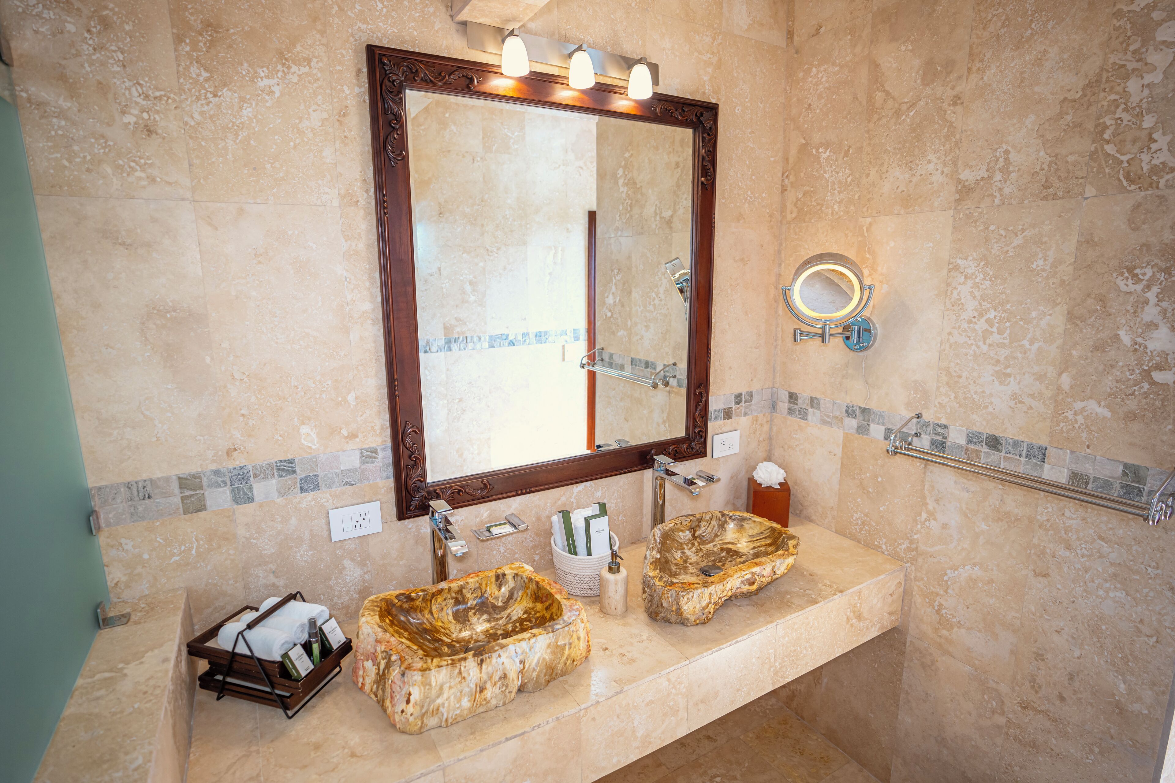 A bathroom with a marble sink, a large mirror, and a towel rack.