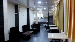 Un restaurant au décor noir et blanc, avec un comptoir et un escalier.