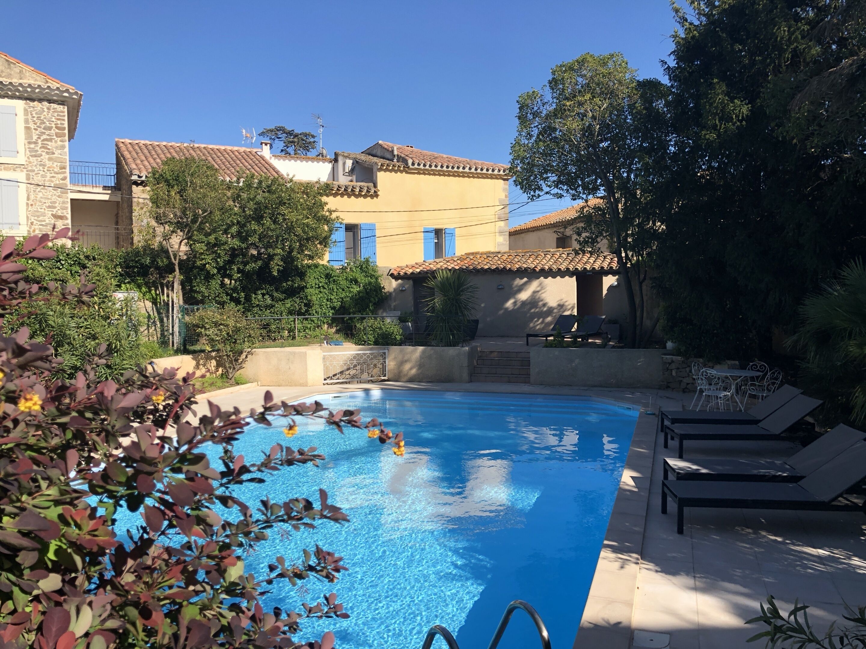 Una piscina al aire libre, tumbonas