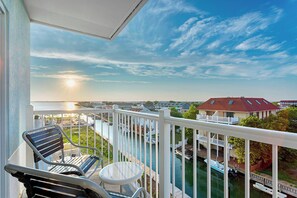 Een balkon met uitzicht op een jachthaven en huizen.