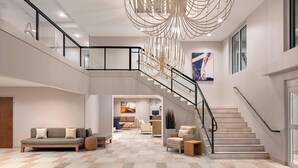 Un intérieur spacieux comprenant un escalier, un canapé et un coin repas.