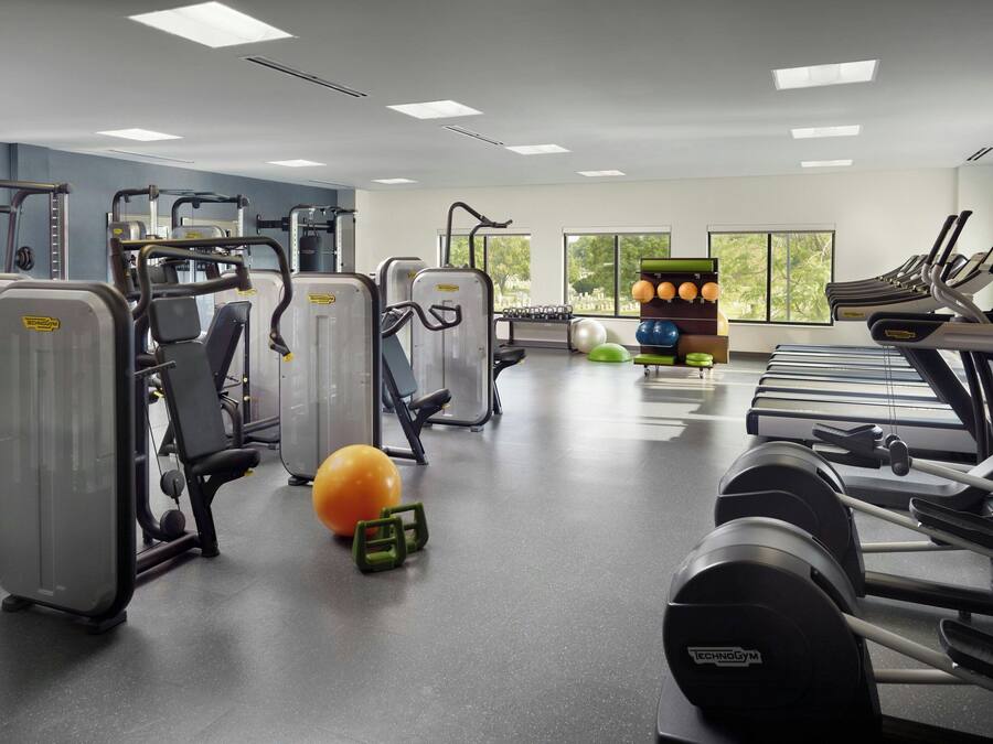 A gym with various exercise equipment, treadmills, and exercise balls.