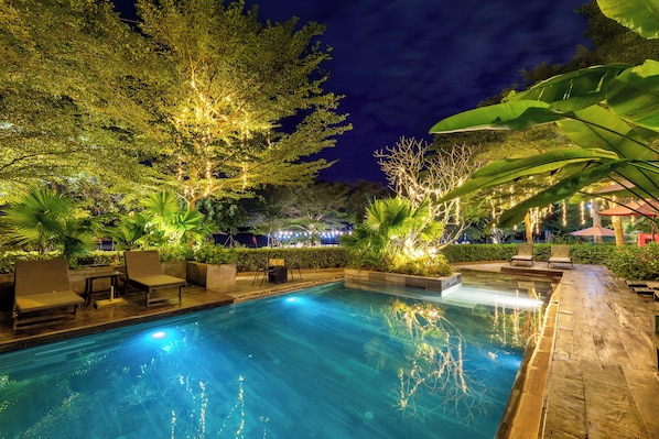 Una piscina al aire libre, tumbonas