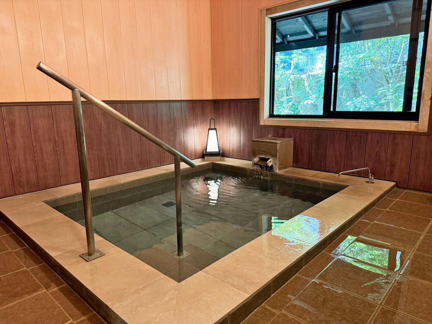 A hot tub with a wooden wall and a window.
