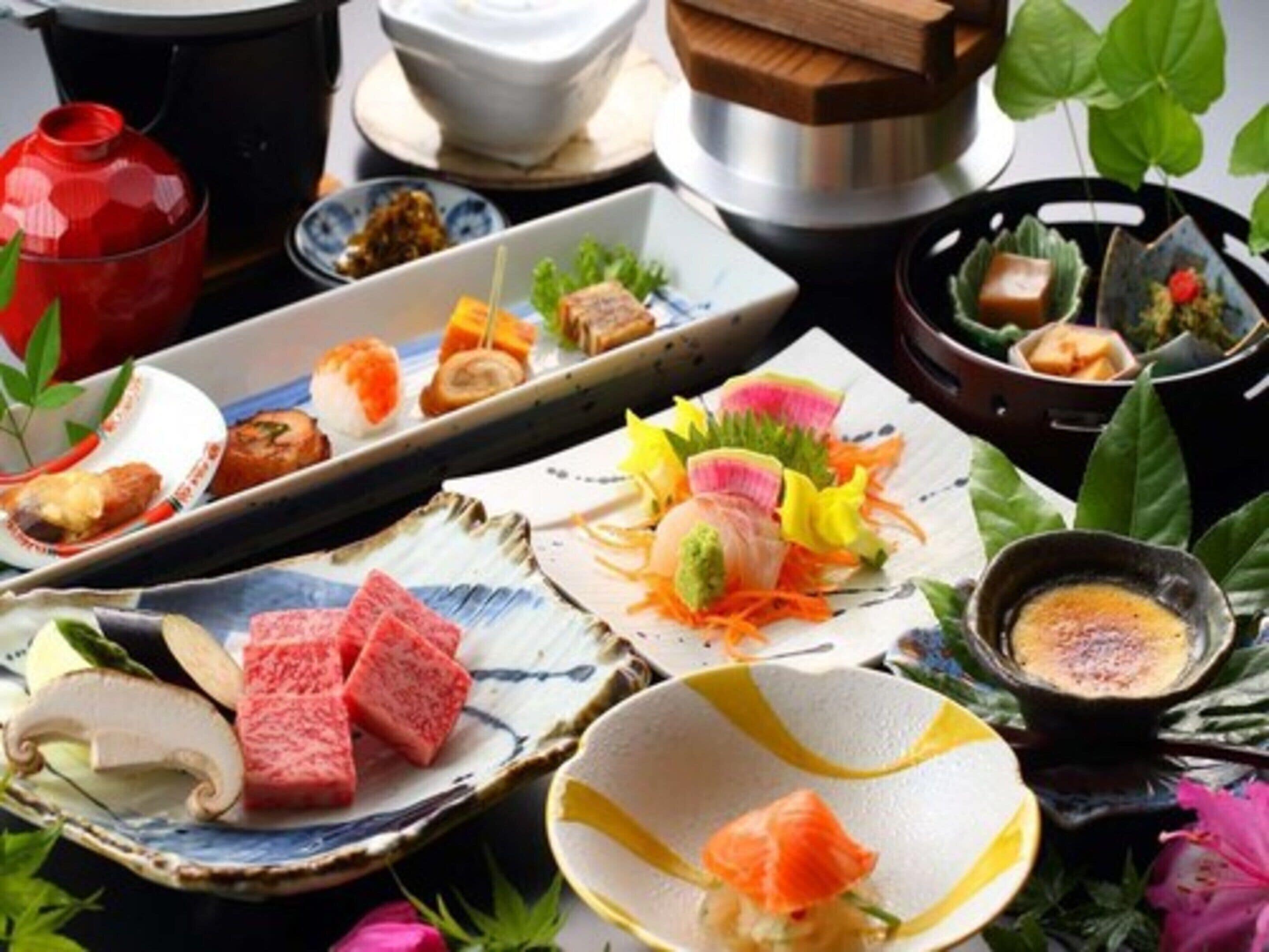 Variedad de platos de sushi sobre una mesa con un hervidor y un pequeño recipiente de salsa.
