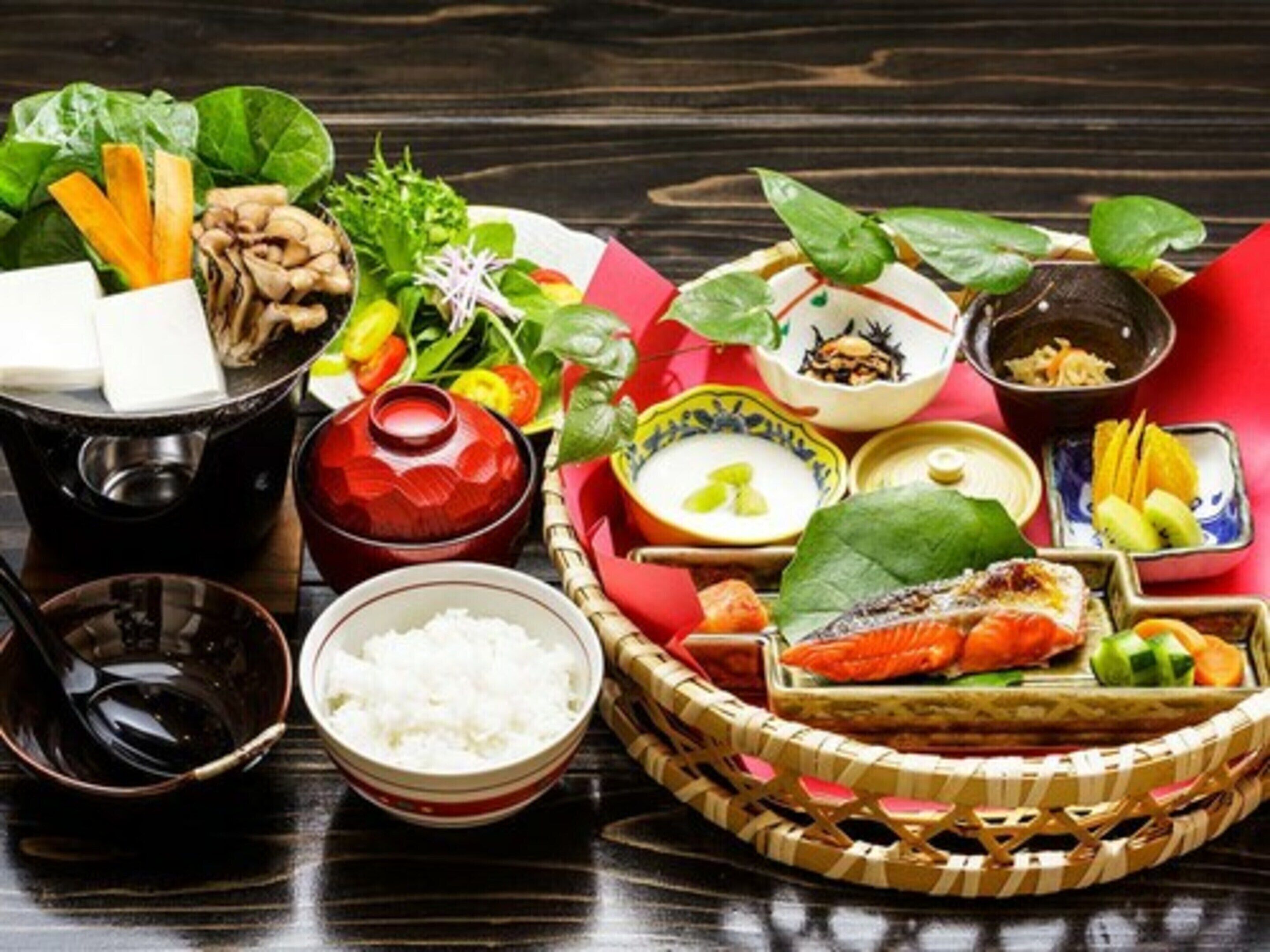Uma refeição tradicional japonesa com diversos pratos, incluindo sushi, arroz e vegetais.