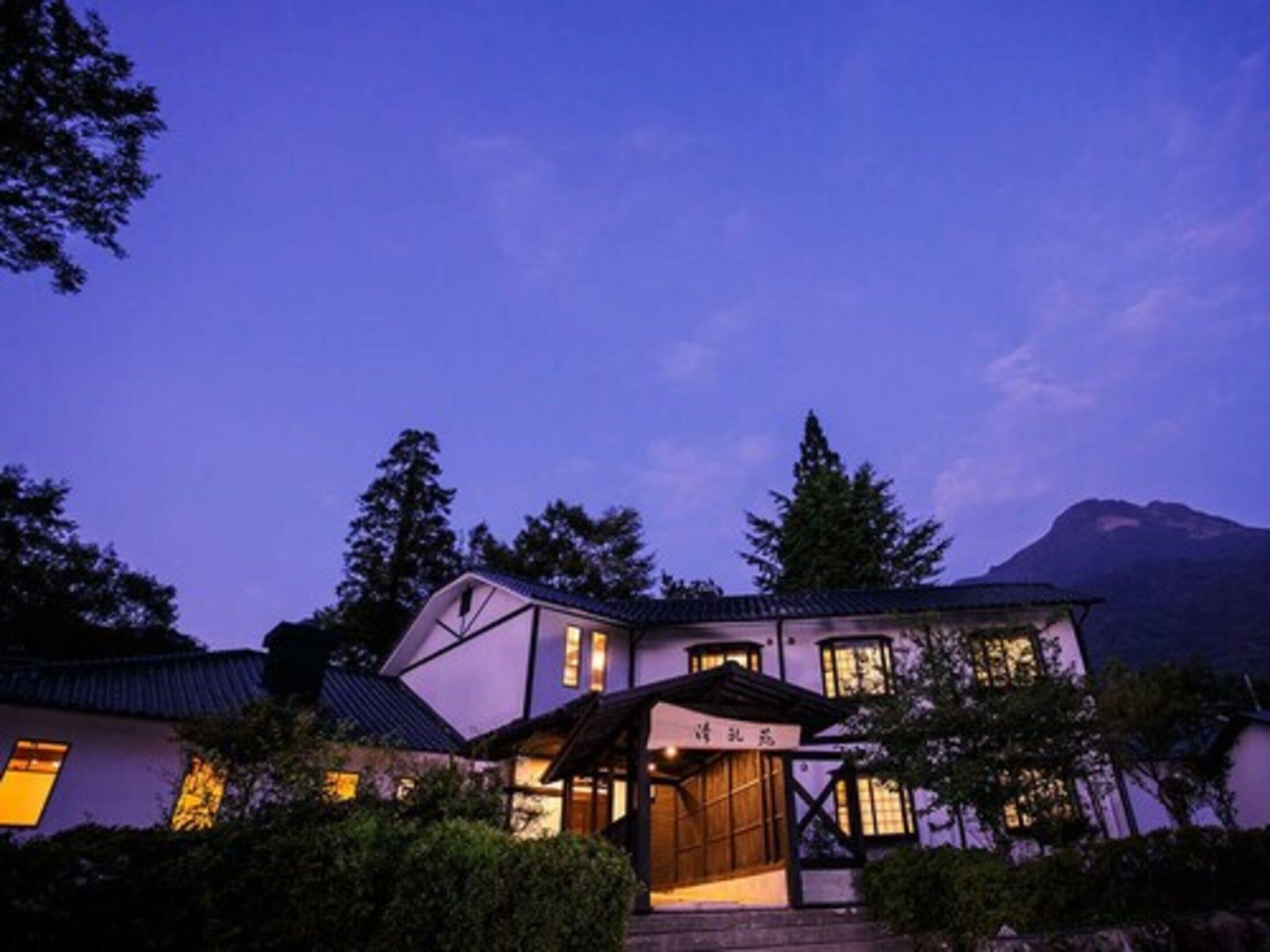 A traditional Japanese-style building with a prominent entrance and a mountain in the background.