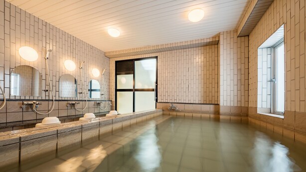 A modern indoor swimming pool with multiple showerheads and a large window.