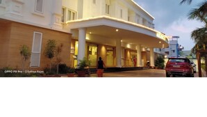 Um hotel com entrada coberta, colunas e a placa 'EDGAT LODGE'.