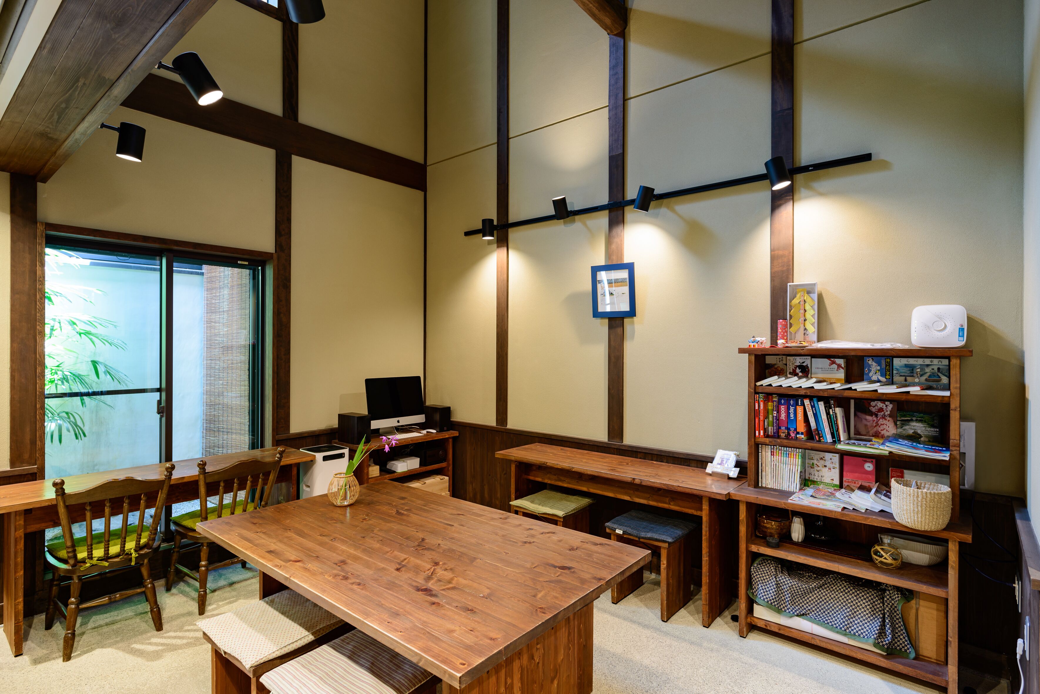 Une pièce de style japonais traditionnel, avec un sol recouvert de tatamis, une basse table en bois et une bibliothèque remplie de livres et d’objets décoratifs.