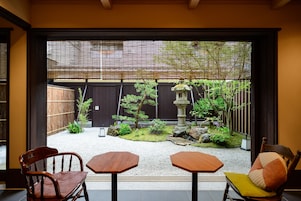 Una habitación tradicional japonesa con suelo de tatami, una mesa baja y dos sillas.