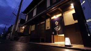 A traditional Japanese building with a wooden exterior, a visible entrance, and a sign with Japanese characters. - Luck You Kyoto (Kyoto)